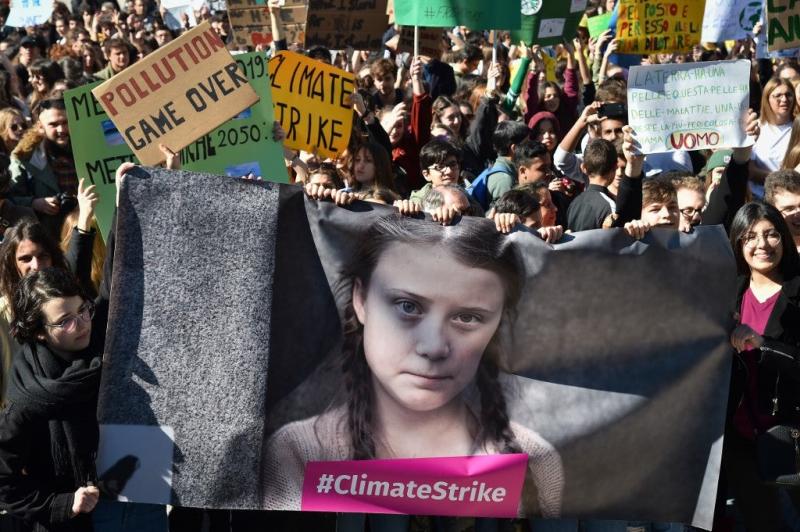People and students hold placards and a banner showing 16-year-old Swedish political activist Greta Thunberg in a protest against global warming in central Rome on March 15, 2019. Andreas SOLARO / AFP